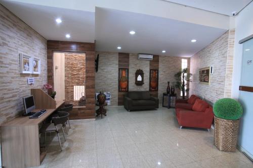a living room with couches and a desk with a computer at Larison Economy by Easy Hotéis in Porto Velho