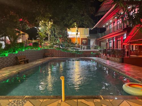 a swimming pool in the middle of a building at night at Greenwood Resort in Dhamni