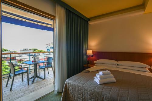 a hotel room with a bed and a balcony at Hotel Rialto in Grado