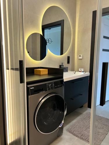 a bathroom with a washing machine and a mirror at Apartament w Kębłowie in Kębłowo