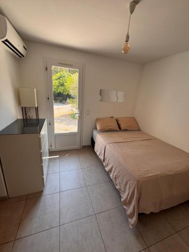 a bedroom with a bed and a dresser and a window at Le Pavillon du Cap d'Antibes in Antibes