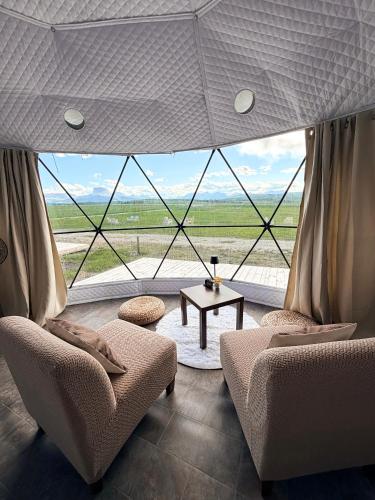 a room with two chairs and a table in front of a large window at Chief Mountain Cabins in Carway