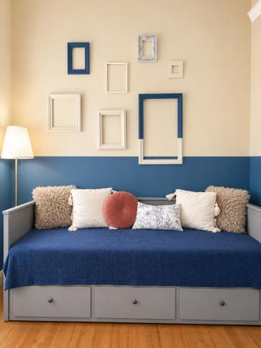 a room with a bed with blue walls and mirrors at Retro Apartment Patras in Patra