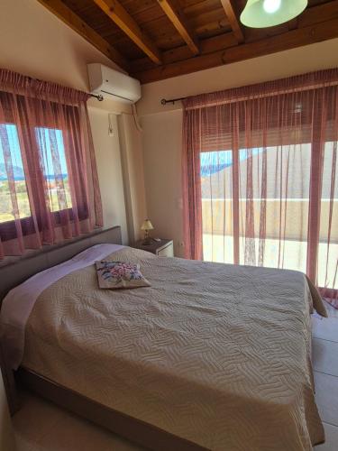 a bedroom with a bed and two windows at Seaside Vatera in Vatera