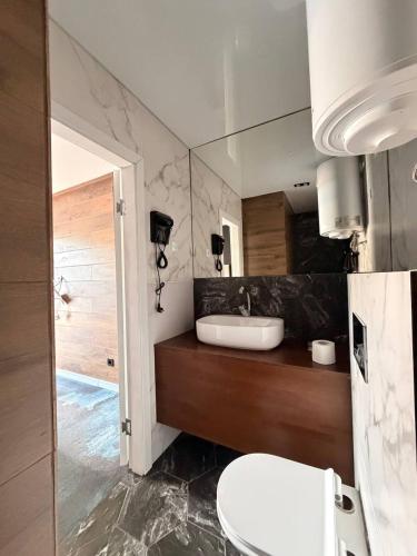 a bathroom with a sink and a toilet and a mirror at White Villas Koblevo in Koblevo