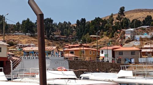 a group of boats are docked in a village at Hospedaje Mamani de isla amantani in Puno