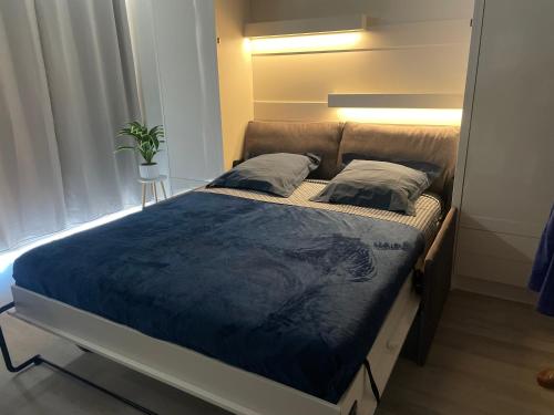 a bedroom with a bed with a blue comforter at Studio cosy avec terrasse, vue mer in Quiberon