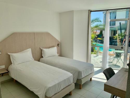 a bedroom with two beds and a view of a pool at Le Clos de Sangonis in Saint-André-de-Sangonis