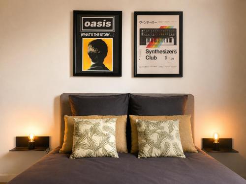a bed with two pictures on the wall and two lamps at Appart T3 Stratégique - Parking - Accès A64 in Portet-sur-Garonne