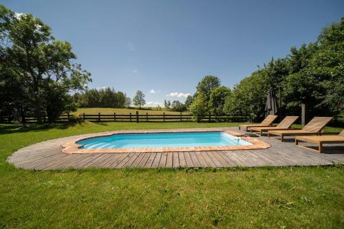 a swimming pool in the middle of a field at Płowce 7 - Mazurski dom z basenem i SPA in Płowce