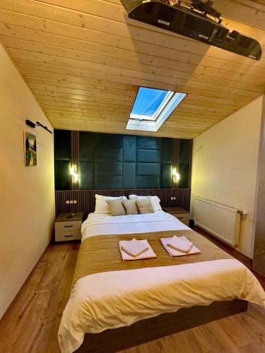 a large bedroom with two beds and a skylight at Къща за гости Шанови in Gʼovren