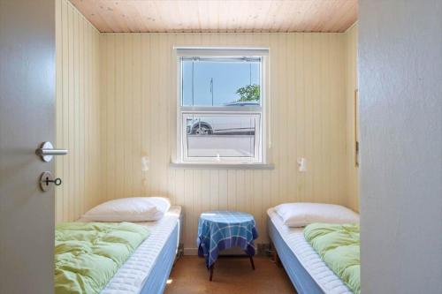 two beds in a room with a window at LF15135-Farso-Strandvejen-35-B in Hvalpsund