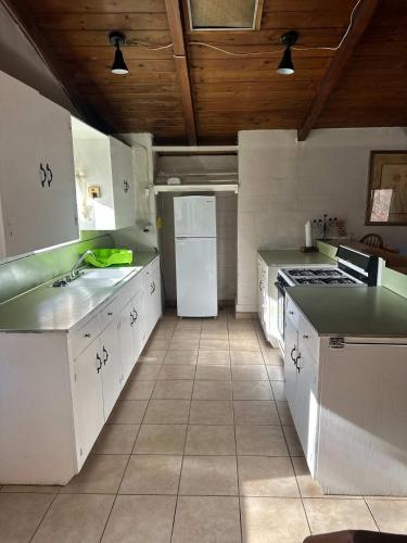 a kitchen with white counters and a white refrigerator at Rancho Meling Casa Felipe in Camalú