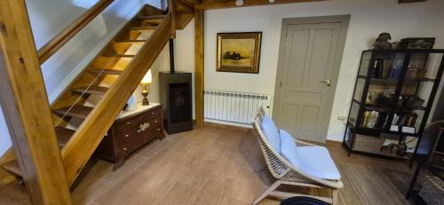 a room with a staircase with a chair and a desk at Casa Coba in Camijanes