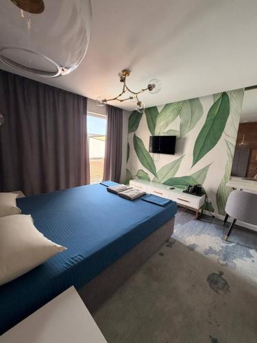 a bedroom with a large blue bed with a mural at White Villas Koblevo in Koblevo