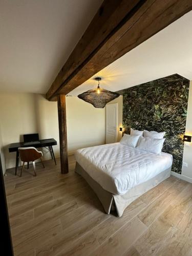 a bedroom with a bed and a desk with a piano at Suite Véloscénie in Lèves