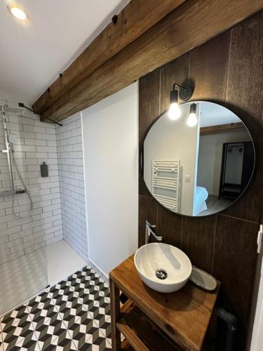 a bathroom with a sink and a mirror at Suite Véloscénie in Lèves