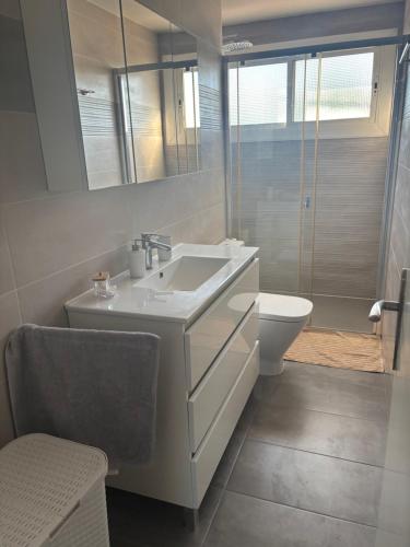 a white bathroom with a sink and a toilet at Appartement Cambrils in Cambrils