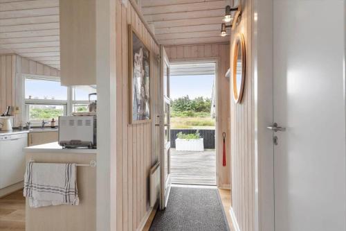 a kitchen with a door leading to a yard at 402-Harboore-Flyvholmvej-23 in Harboør
