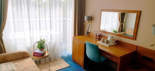 a bedroom with a desk with a mirror and a chair at Alka guest house in Palanga