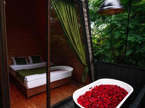 a balcony with a bed and a tub of roses at Porto Gumati in Kutaisi