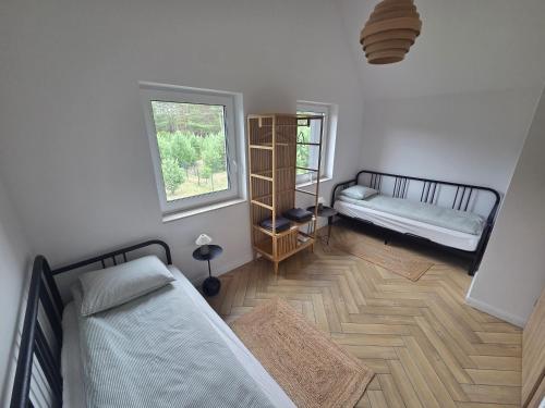 a bedroom with two beds and a window at Dom nad Zbrzycą MODRY in Swornegacie