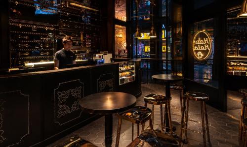 a man standing at a bar in a bar with stools at Hotel Relax III in Taipei