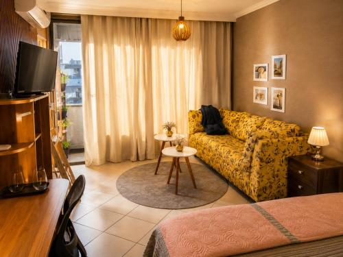 a living room with a couch and a table at Hotel Copacabana Stay in Serra