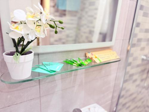a glass shelf with a vase of flowers on it at Castle Harbour 209 in Los Cristianos