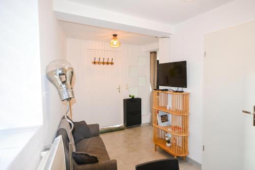 a living room with a couch and a flat screen tv at Quiet and bright studio in Gorze in Gorze
