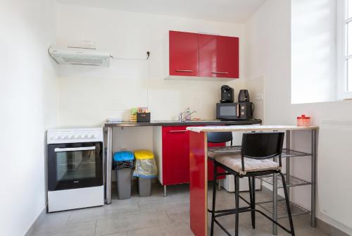 a small kitchen with red cabinets and a counter at Quiet and bright studio in Gorze in Gorze
