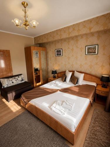 a bedroom with a large bed and a couch at Hotel Casa Italia in Calafat