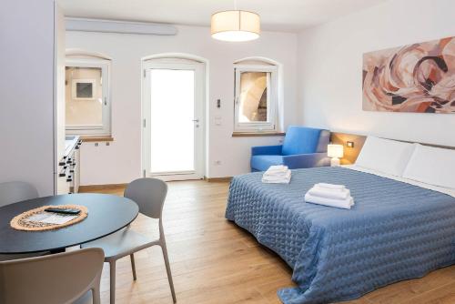 a bedroom with a blue bed and a table and chairs at L'angolo del Forte in Rivoli Veronese