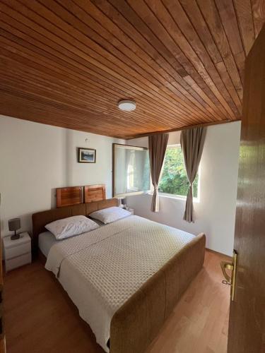ein Schlafzimmer mit einem großen Bett und einer Holzdecke in der Unterkunft Dva Bora Holiday Home in Banja Luka