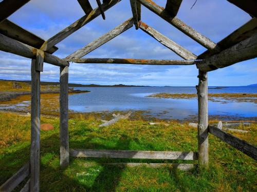 a wooden fence in front of a body of water at Borgir - The House by the Sea in Borgir
