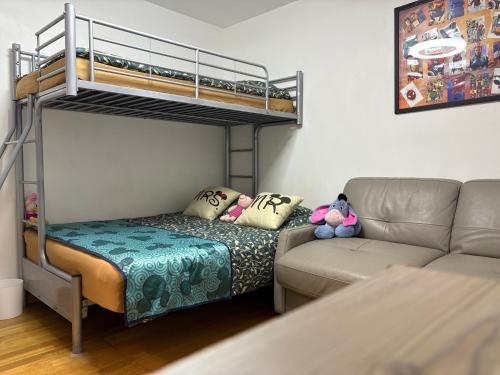 a living room with a bunk bed and a couch at chez christian&astrid Next to Disneyland Paris in Penchard