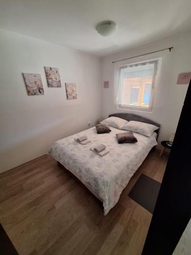 a bedroom with a bed and a window at Apartment Lela - self check-in and check-out in Otočac