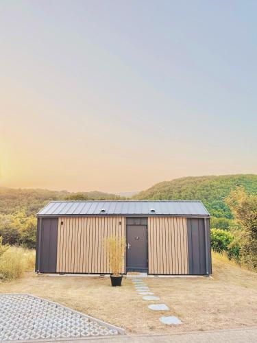 a small building with a door in a field at Tiny House mit Whirlpool und Sauna in Bermel