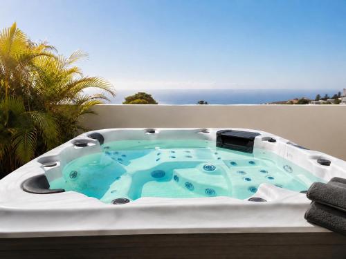 a hot tub on a balcony with the ocean in the background at Atlantic View Loft - Spa & Sunset in La Orotava