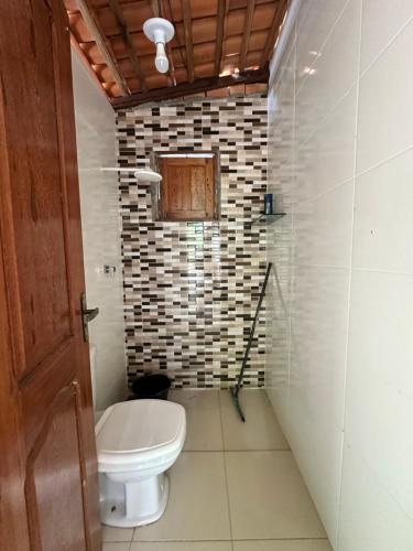 a bathroom with a white toilet in a room at Nosso Chalé in Marapanim