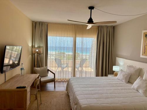 a bedroom with a bed and a desk and a window at Lam Hotel Foya Branca in São Pedro