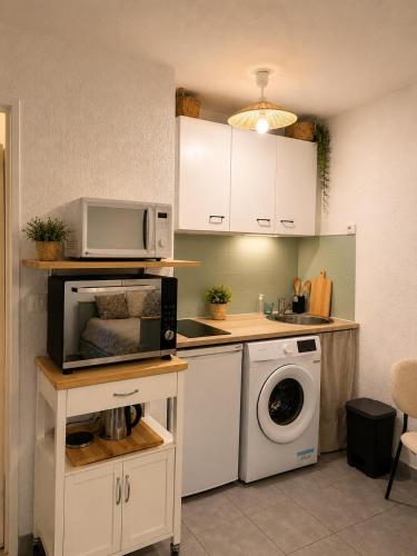 a kitchen with a microwave and a washing machine at Charmant studio,Terrasse et Parking in Montpellier