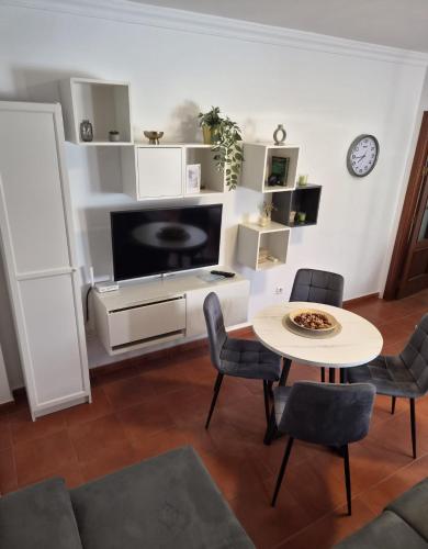 a living room with a tv and a table and chairs at Apartamento click center in Ronda