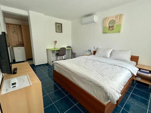 a bedroom with a bed and a table and a desk at Casa Double M, Vama Veche in Vama Veche