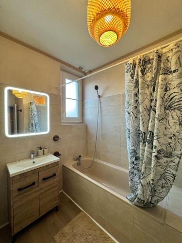 a bathroom with a bath tub and a sink at L'Echappée Belle in Paray-le-Monial