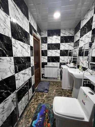 a bathroom with a black and white tile wall at Noyemberyan Central Apartment in Noyemberyan