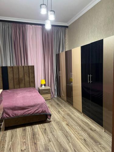 a bedroom with a bed and a dresser and curtains at Noyemberyan Central Apartment in Noyemberyan