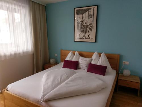 Schlafzimmer mit einem weißen Bett und roten Kissen in der Unterkunft Apartment Lasch in Adler Resort in Kaprun