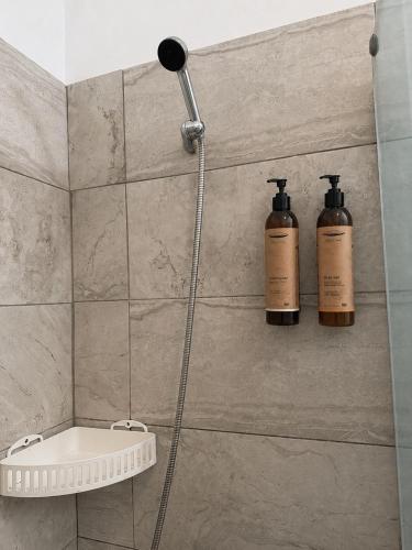 a shower with two shampoo bottles on the wall at Oroklini Hills Modern Sea View Apartments in Oroklini