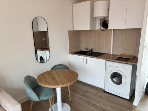 a kitchen with a table and a washing machine at Studio 7 in Fos-sur-Mer